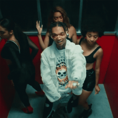 A Man In A White Jacket With A Skull On His Shirt Is Surrounded By Women GIF
