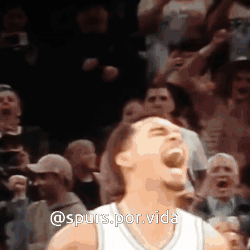 A Man In A White Jersey Is Screaming In Front Of A Crowd With The Words @Spurs.por.vida Above Him GIF