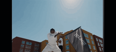 A Man In A White Karate Uniform Is Holding A Flag That Says Pelang On It GIF