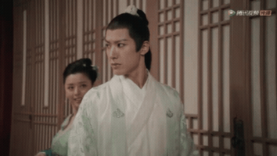 A Man In A White Kimono Is Standing Next To A Woman In A Green Dress .. GIF