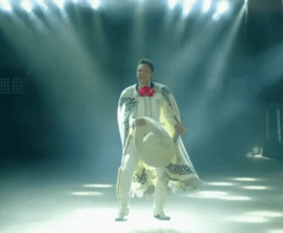 A Man In A White Poncho Holds A Sombrero GIF