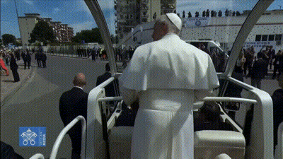 A Man In A White Robe Is Sitting In A Car With A Sign That Says ' Milano ' On It GIF
