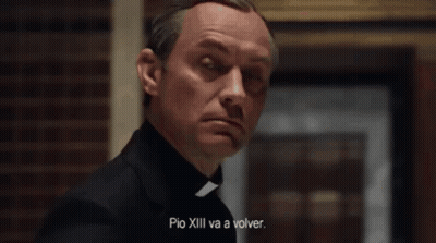A Man In A White Robe Is Sitting In A Chair With The Words " Quien Es El Papa Ahora " Written On The Bottom GIF