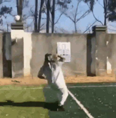 A Man In A White Robe Is Standing On A Tennis Court . GIF