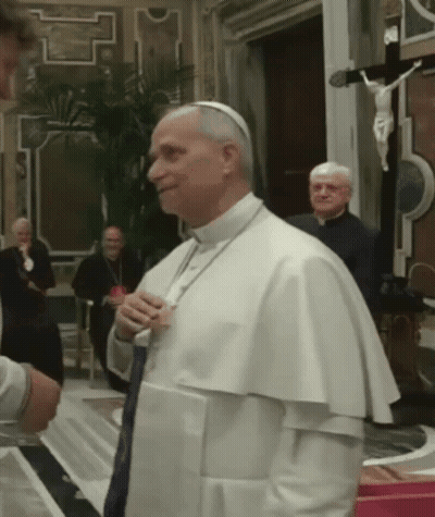 A Man In A White Robe Is Talking To Another Man GIF