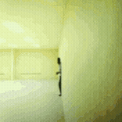 A Man In A White Shirt And Black Pants Is Running In A Room GIF