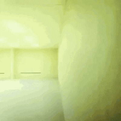 A Man In A White Shirt And Black Pants Is Running In A Room With Yellow Walls GIF