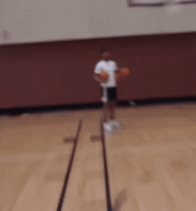 A Man In A White Shirt And Black Shorts Is Holding Two Basketballs In His Hands GIF