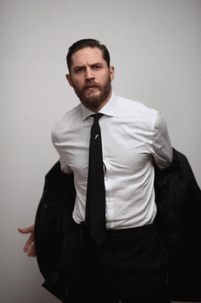 A Man In A White Shirt And Black Tie Is Holding His Jacket GIF