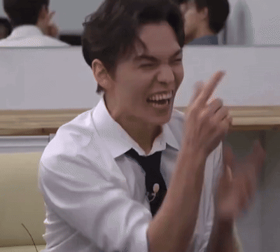 A Man In A White Shirt And Black Tie Is Laughing And Clapping His Hands . GIF