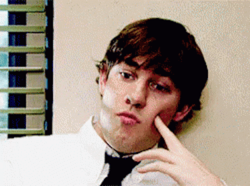 A Man In A White Shirt And Black Tie Is Making A Face GIF