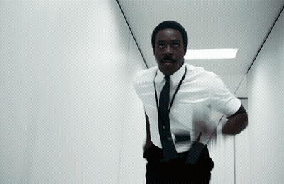 A Man In A White Shirt And Black Tie Is Running In A Hallway GIF