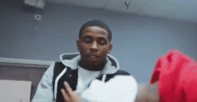 A Man In A White Shirt And Black Vest Is Standing Next To A Woman In A Red Jacket . GIF