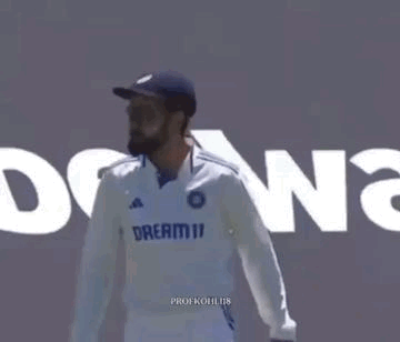 A Man In A White Shirt And Blue Hat Is Standing In Front Of A Wall With The Word Dreamii On It . GIF