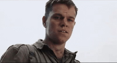A Man In A White Shirt And Blue Jacket Is Looking At The Camera With A Serious Look On His Face . GIF