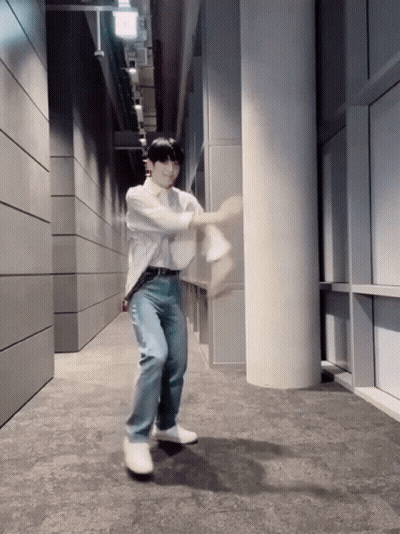 A Man In A White Shirt And Blue Jeans Is Dancing GIF