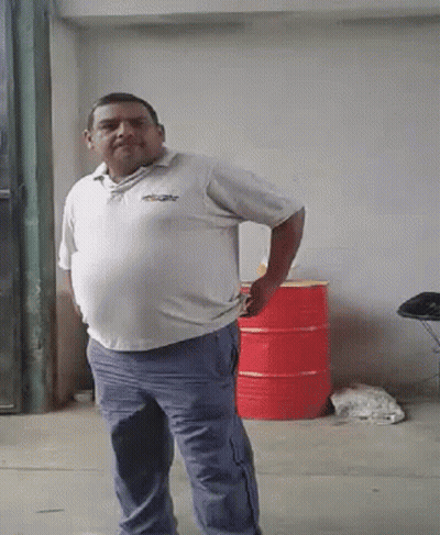 A Man In A White Shirt And Blue Pants Is Standing With His Hands On His Hips GIF