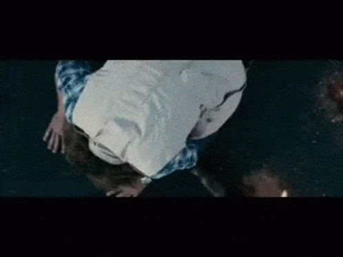 A Man In A White Shirt And Blue Plaid Shirt Is Falling Into The Water GIF