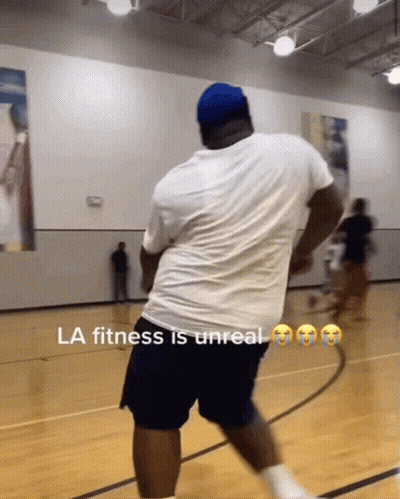 A Man In A White Shirt And Blue Shorts Is On A Basketball Court With The Caption La Fitness Is Unreal GIF