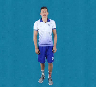 A Man In A White Shirt And Blue Shorts Stands In A Yoga Pose With His Arms Outstretched GIF