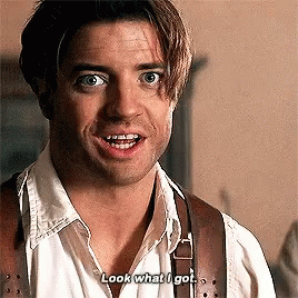 A Man In A White Shirt And Brown Suspenders Is Smiling And Talking . GIF