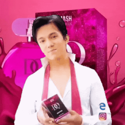 A Man In A White Shirt And Pink Tie Is Holding A Box Of Ash Perfume GIF