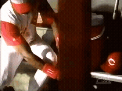 A Man In A White Shirt And Red Hat Is Holding A Red Glove With The Letter C On It GIF