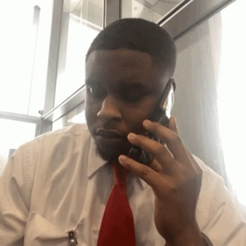 A Man In A White Shirt And Red Tie Is Talking On His Cell Phone GIF
