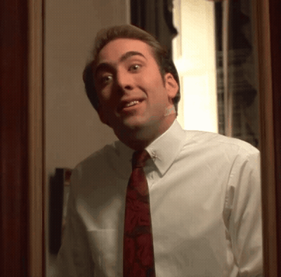 A Man In A White Shirt And Red Tie Looks At Himself In The Mirror GIF