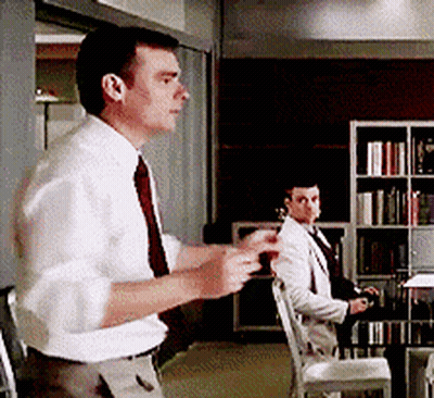 A Man In A White Shirt And Red Tie Stands In A Room GIF
