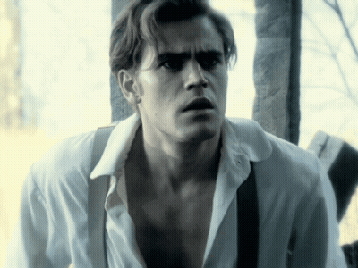 A Man In A White Shirt And Suspenders Is Looking At Something GIF