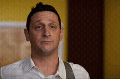 A Man In A White Shirt And Suspenders Is Making A Face GIF