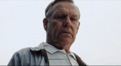 A Man In A White Shirt And Tie Is Looking At The Camera With A Serious Look On His Face . GIF