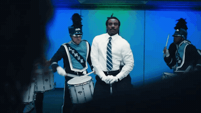 A Man In A White Shirt And Tie Is Playing A Drum GIF