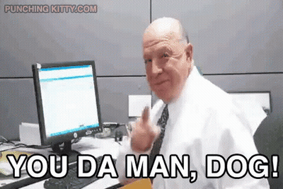 A Man In A White Shirt And Tie Is Sitting At A Desk In Front Of A Computer And Says You Da Man Dog . GIF
