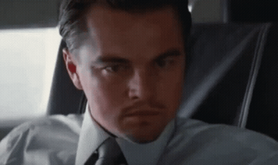 A Man In A White Shirt And Tie Is Sitting In A Car . GIF