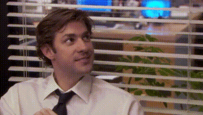 A Man In A White Shirt And Tie Is Sitting In Front Of A Window In An Office . GIF