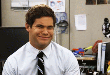 A Man In A White Shirt And Tie Is Smiling In An Office GIF