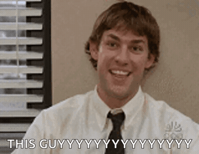 A Man In A White Shirt And Tie Is Smiling While Sitting In Front Of A Window In An Office . GIF
