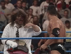 A Man In A White Shirt And Tie Is Standing In A Wrestling Ring GIF