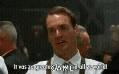 A Man In A White Shirt And Tie Is Standing In Front Of A Group Of Men And Saying `` It Was Ze Greate Game ! '' GIF