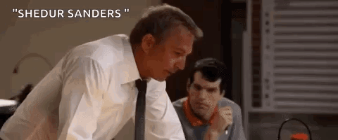 A Man In A White Shirt And Tie Is Standing Next To Another Man In A Room . GIF
