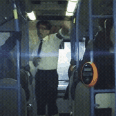 A Man In A White Shirt And Tie Is Standing On A Bus With His Arms Outstretched GIF