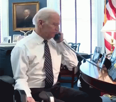 A Man In A White Shirt And Tie Is Talking On A Cell Phone GIF