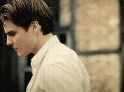 A Man In A White Shirt And Tie Looks Down At Something GIF