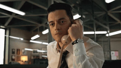A Man In A White Shirt And Tie Talking On A Telephone GIF