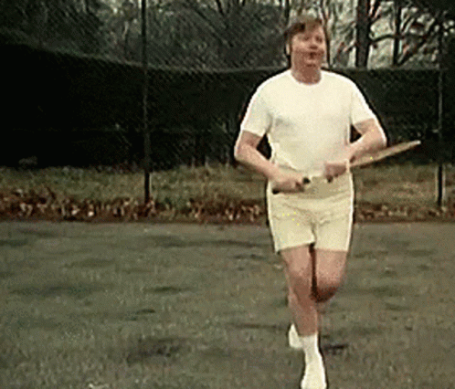 A Man In A White Shirt And White Shorts Is Running With A Tennis Racquet GIF