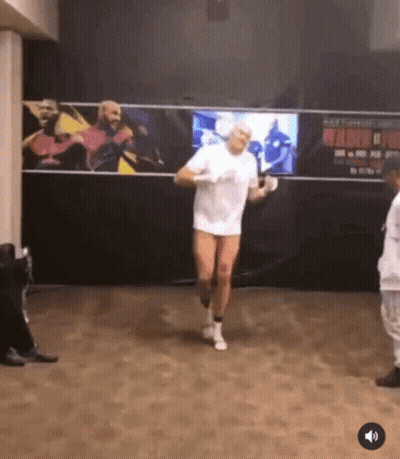 A Man In A White Shirt And White Socks Is Jumping Rope In A Gym GIF