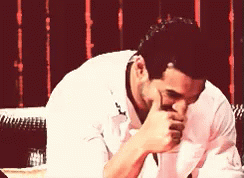 A Man In A White Shirt Covering His Mouth With His Hands GIF