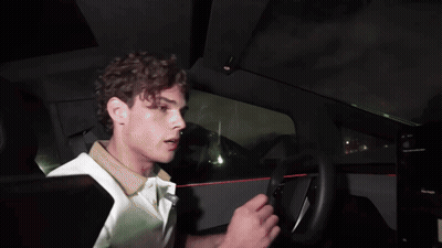 A Man In A White Shirt Driving A Car GIF